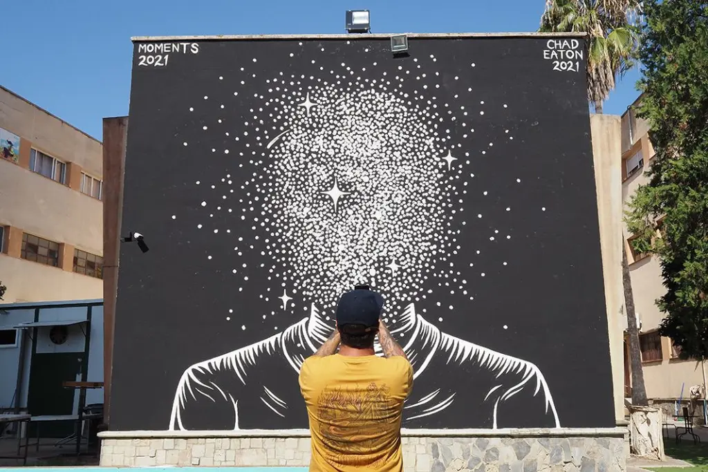 Chad Eaton terminando su mural en la escuela